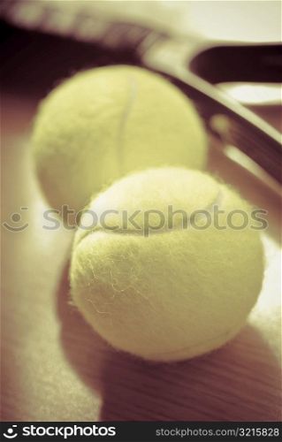 Close-up of tennis balls with a tennis racket