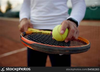 Close up of tennis player holding ball on racket for serving. Sports equipment for training workout and professional tournament match. Close up of tennis player holding ball on racket for serving