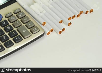 close up of the calculator and the cigarette on white background