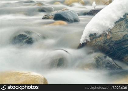 Close-up of the current between the stones of a mountain stream, photographed with a long exposure