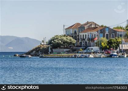 close-up of the dock of the fiskardo village with boats and their ancient constructions and in the background the mountains of the island of kefalonia greece