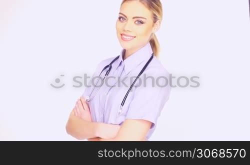 Close up of the face of a beautiful young female doctor in blue shirt and a stethoscope smiling at the camera