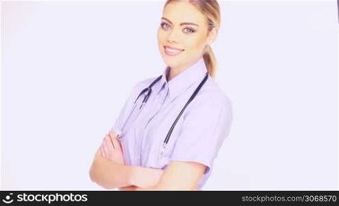 Close up of the face of a beautiful young female doctor in blue shirt and a stethoscope smiling at the camera