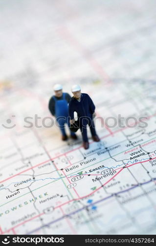 Close-up of the figurines of two construction workers on a map