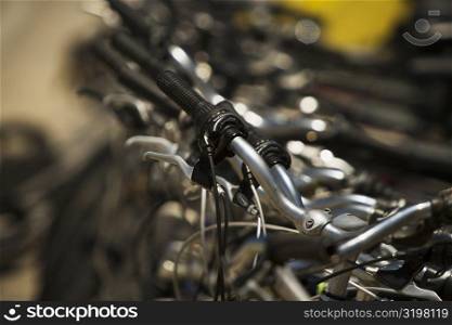 Close-up of the handlebars of parked cycles