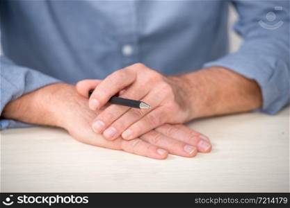 close up of the hands of senior man with a pencil