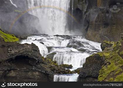 Close up of the Ofaerufoss waterfal in the Eldgja volcanic canyon of Iceland&rsquo;s Landmannalaugar national park with a rainbow in front