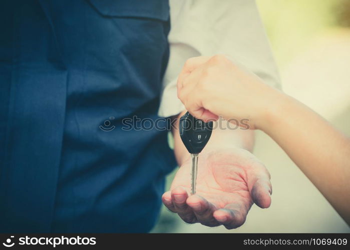 Close up of the woman hand is sending the car keys to the car mechanic. The concept of trust And confidence in using the service