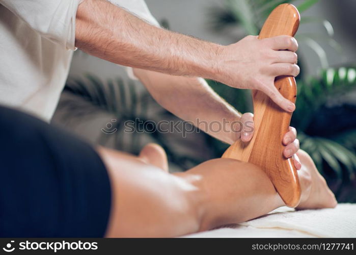 Close up of therapist doing anti cellulite Madero therapy massage to sporty young woman