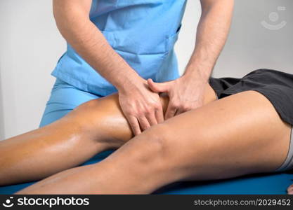 Close-up of therapist massaging young man&rsquo;s leg. High quality photo.. Close-up of therapist massaging young man&rsquo;s leg