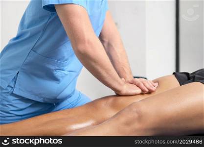 Close-up of therapist massaging young man&rsquo;s leg. High quality photo.. Close-up of therapist massaging young man&rsquo;s leg
