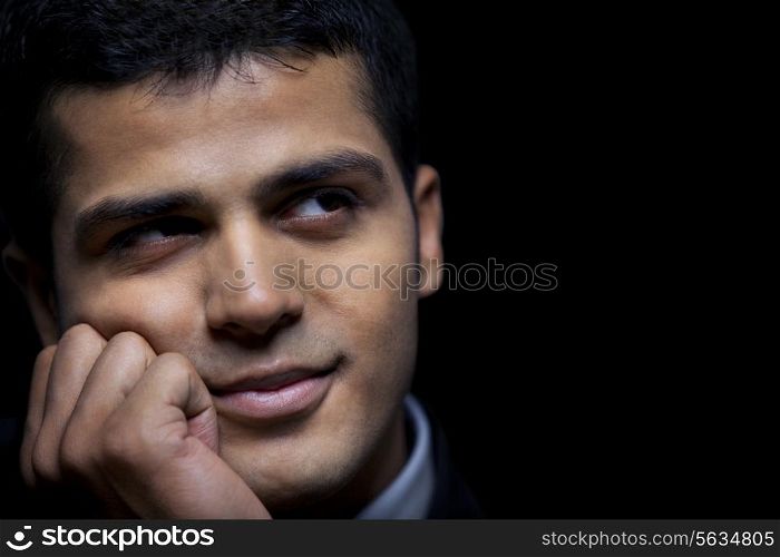 Close-up of thoughtful business man over black background