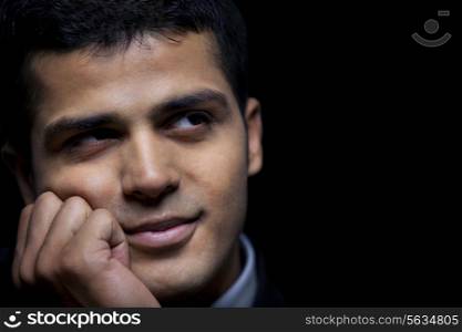 Close-up of thoughtful business man over black background