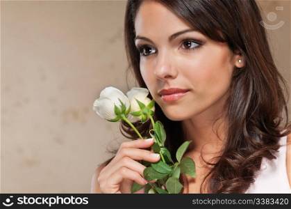 Close-up of thoughtful pretty young woman holding white roses