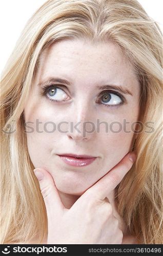 Close-up of thoughtful young woman with hand on chin looking away