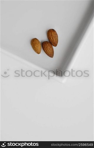 Close-up of three almonds on a tray