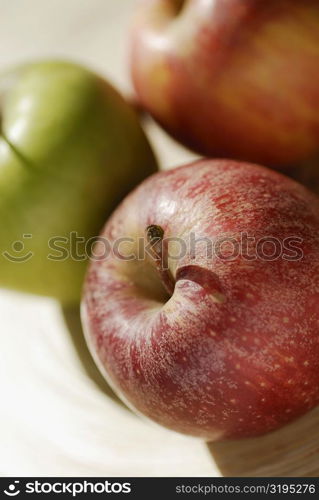 Close-up of three apples on a tray