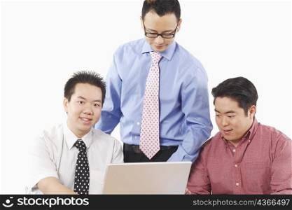 Close-up of three businessmen using a laptop