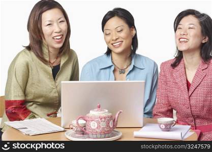 Close-up of three businesswomen in front of a laptop