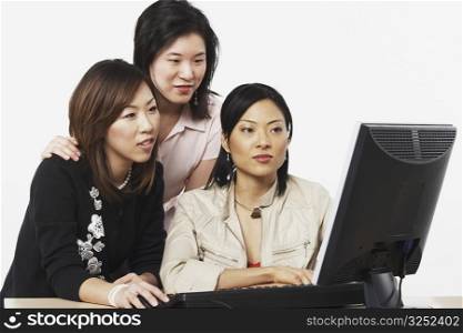 Close-up of three businesswomen looking at a computer