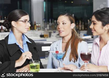 Close-up of three businesswomen talking in a bar