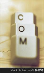 Close-up of three computer keys spelling the word COM