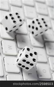 Close-up of three dice on a computer keyboard