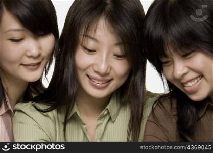 Close-up of three female office workers smiling