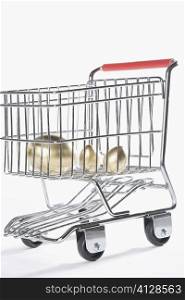 Close-up of three golden eggs in a shopping cart