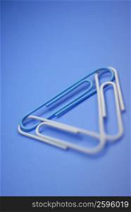 Close-up of three paper clips in a triangle