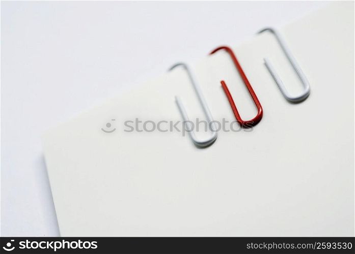 Close-up of three paper clips on a sheet of paper