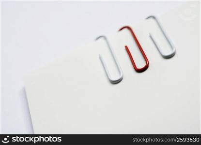 Close-up of three paper clips on a sheet of paper