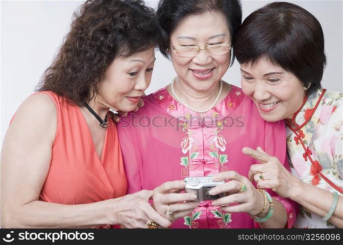 Close-up of three senior women looking at a digital camera and smiling