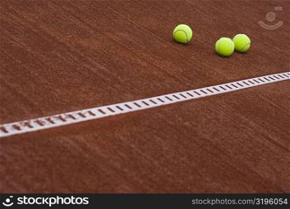 Close-up of three tennis balls in a court