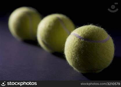 Close-up of three tennis balls in a row