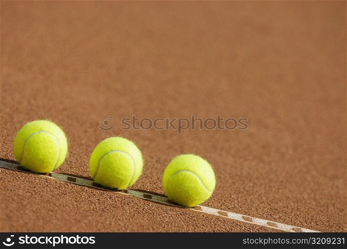 Close-up of three tennis balls on the yard line