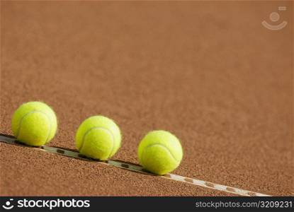 Close-up of three tennis balls on the yard line