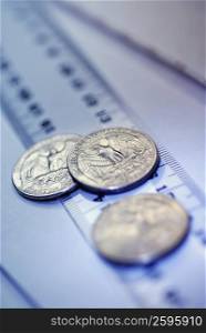 Close-up of three US coins on a ruler