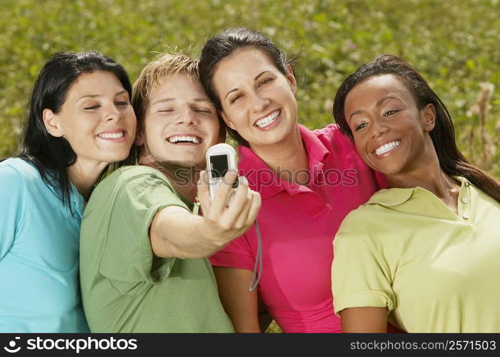 Close-up of three young women and a young man photographing themselves