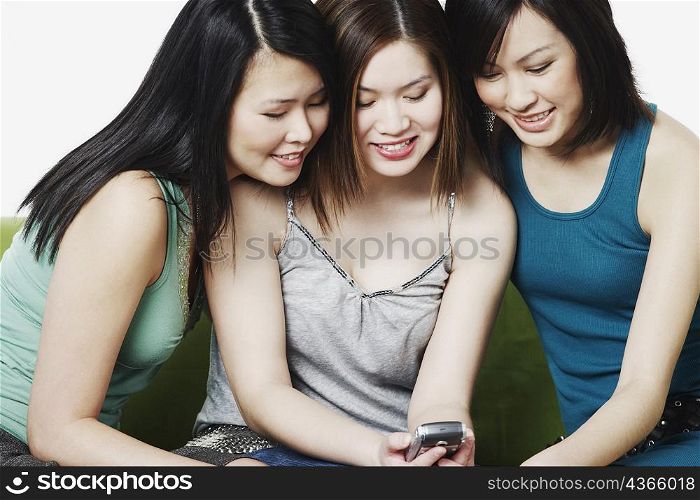 Close-up of three young women holding a mobile phone