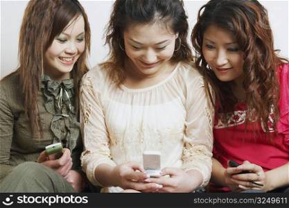 Close-up of three young women looking at a mobile phone
