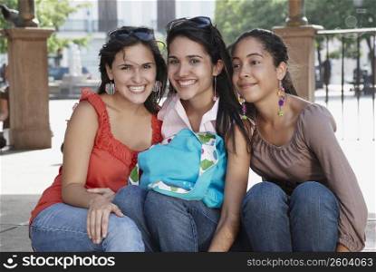 Close-up of three young women sitting and smiling