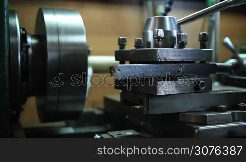 Close up of tools and equipment of old-fashoin manual lathe machine. Worker operating vintage turning lathe machine in the workshop.
