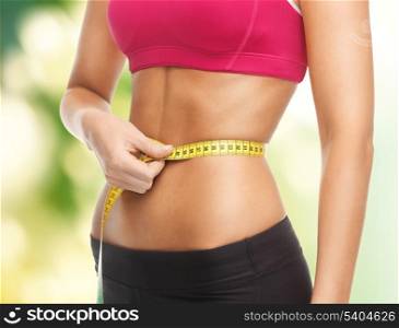 close up of trained belly with measuring tape