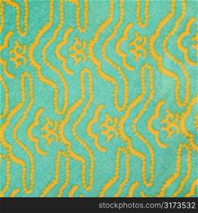 Close-up of turquois vintage fabric with repetitive yellow designs printed on polyester.