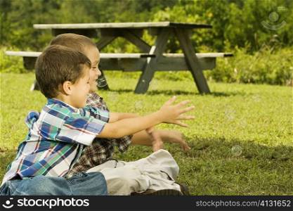 Close-up of two boys catching bubbles