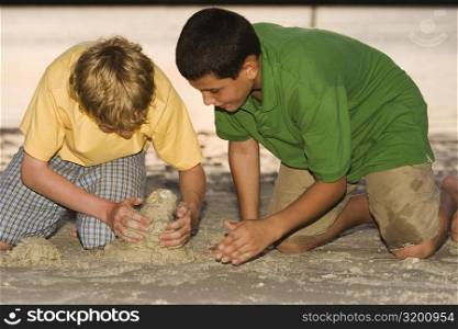 Close-up of two brothers playing in sand