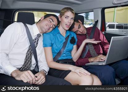 Close-up of two businessmen leaning on a businesswoman&acute;s shoulders in a car
