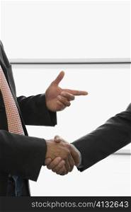 Close-up of two businessmen shaking hands at an airport