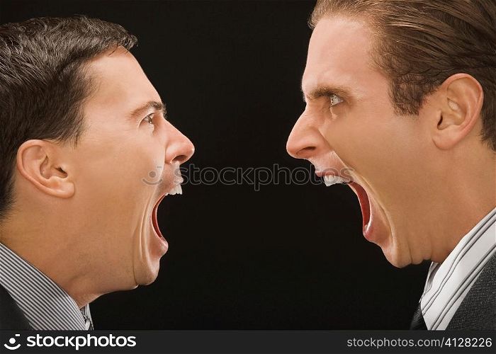 Close-up of two businessmen shouting at each other